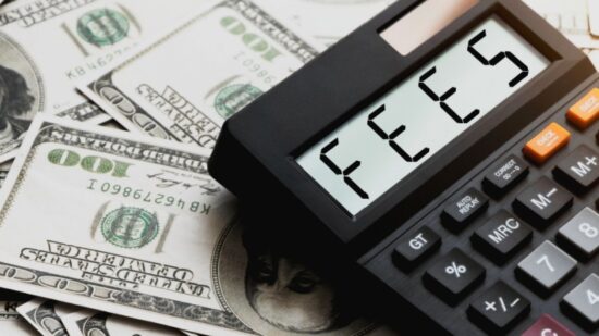 Calculator with the word FEES on the calculator placed on the dollar-Shutterstock_2222079121